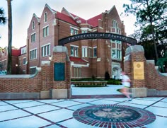 a person running in front of the university of florida sign and entrance to the building