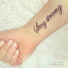 someone has a tattoo that says, stay strong on their foot and the word is written in cursive font