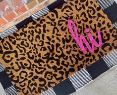 a leopard print door mat with the word w on it and pink monogrammed letters