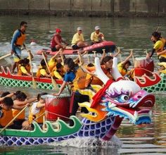 people in dragon boats on the water