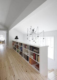 an empty room with bookshelves and chandelier hanging from the ceiling in it