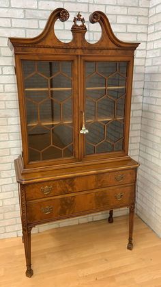 an old wooden dresser with glass doors and drawers