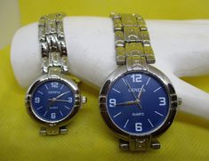 CHOOSE: No 1 Women's OR No 2 Men's New Battery Installed Prior Shipping. These are new never worn Geneva women's and men's quartz watches with round silver-tone metal watch cases, blue faces, white numbers, and bars representing numbers three silver tone metal hands. The watch bands are made out of silvertone metal links with overlapping clasps. The back of these watches is marked Geneva Stainless Steel.  Women's Watch Watch Case width across 15/16 inch. Watch Face width across 11/16 inch. Watch Representing Numbers, Watch Cases, Metal Watch, Ruby Slippers, Blue Face, Unique Beauty, Beautiful Watches, Women's Watch