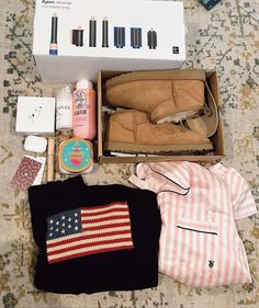 the contents of a purse are laid out on the floor next to an american flag sweater