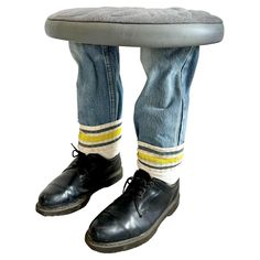 a pair of jeans and black shoes with yellow stripe socks underneath the footrests