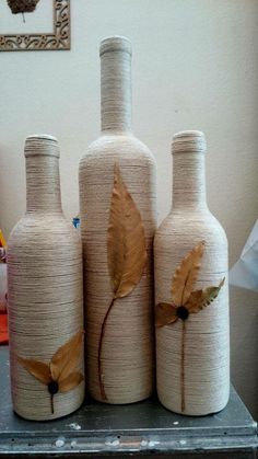 three vases with leaves painted on them