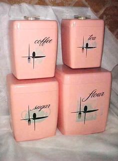 four pink ceramic containers with black writing on them