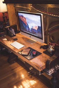 a computer monitor sitting on top of a wooden desk next to a keyboard and mouse