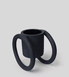 a black coffee cup sitting on top of a table