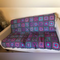 a crocheted blanket sitting on top of a couch