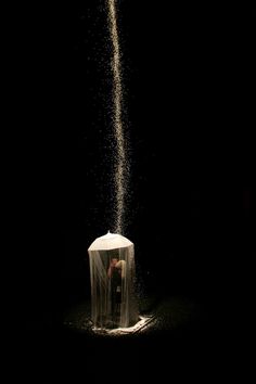 a person standing in front of a white tent covered in sand and sprinkles