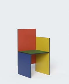 a multicolored table sitting on top of a white floor next to a wall