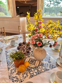 the table is set with flowers and plates, candles, and other items on it