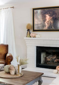 a living room filled with furniture and a fire place in front of a painting on the wall