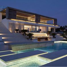 a large modern house with swimming pool and stairs leading up to the upper floor area