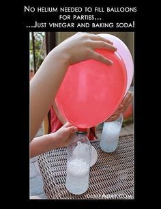 a person holding a pink frisbee in front of two empty plastic water bottles