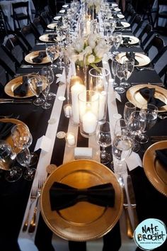 the table is set with black and gold place settings