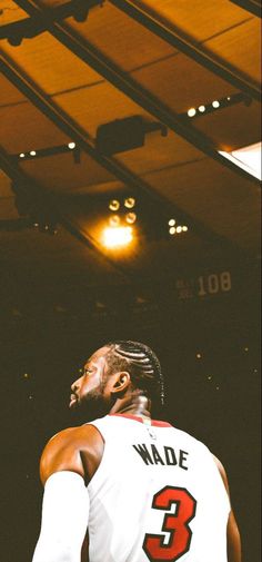 a basketball player is looking up at the sky with his head tilted to the side