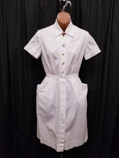 Vintage 1960's Unifemme White Nurse Maid Diner Smock Dress Cotton Collared Uniform Dress.  This dress features a 7 snap and 6 button front closure, 2 deep side pockets, and darts on the bust. Great vintage condition - see pics! Measurements: waist 24, chest 34, shoulder to shoulder 14 1/2, length 38 1/2, hem 2 1/2, sleeve shoulder to cuff 7, sleeve pit to cuff 2 1/2 inches. Classic A-line Vintage Dress With Buttons, Classic A-line Vintage Dress With Button Closure, 1950s A-line Dress With Buttons, Fitted A-line Vintage Dress With Buttons, Classic Button-up Dress For Daywear, Classic Fitted Shirt Dress With Pockets, Classic Daywear Dresses With Pockets, Classic Fitted Shirt Dress With Covered Buttons, Fitted Retro Vintage Dress With Button Closure