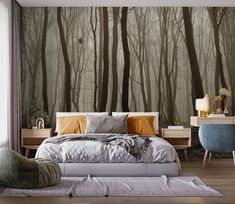 a bedroom with a bed, nightstands and wallpaper that has trees on it