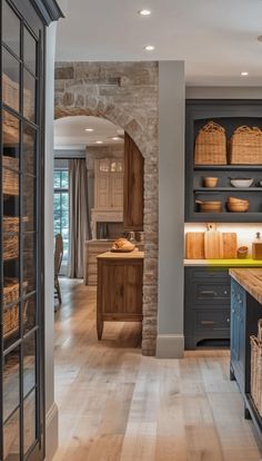 an open kitchen with lots of counter space and wooden cabinets, along with baskets on the shelves