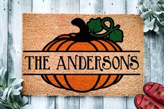 a door mat that says the andersons with a pumpkin on it next to red shoes