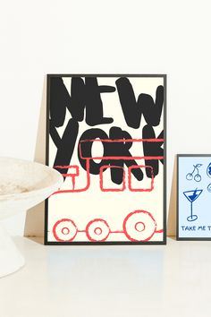 a card with the words new york on it next to a bowl of fruit and an envelope