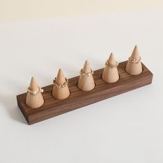 five wooden cones are lined up on a piece of wood