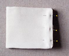 a piece of cloth with yellow pins on it