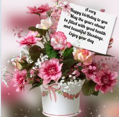 a birthday card with pink flowers in a white vase and a note attached to it