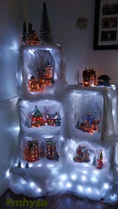 an ice block with christmas lights on it and houses in the snow, all lit up