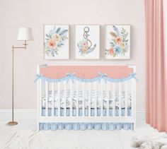 a baby's room with pink walls and blue crib bedding in the corner