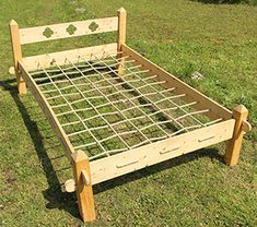 a wooden bed frame sitting in the grass