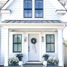 a white house with two wreaths on the front door