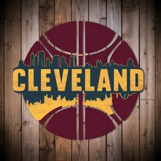 a basketball with the word cleveland painted on it in front of a wooden wall and fence