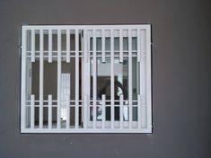 a jail cell with bars on the door and window panes in front of it