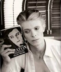 a woman holding up a magazine in front of her face