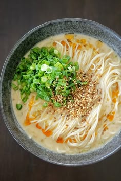 a bowl filled with noodles and vegetables on top of a table