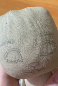 someone is drawing on the back of a pillow that looks like an eyeball and car