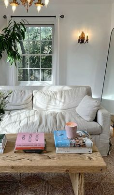 a living room with a couch, coffee table and books on top of the tables