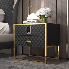 a black and gold nightstand next to a bed with white flowers on it in a bedroom