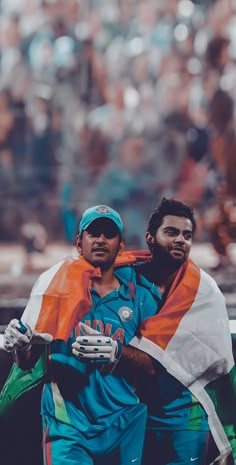 two men in blue and orange uniforms are carrying an orange and white flag on their shoulders