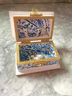 an open pink and blue box sitting on top of a marble counter next to a white wall