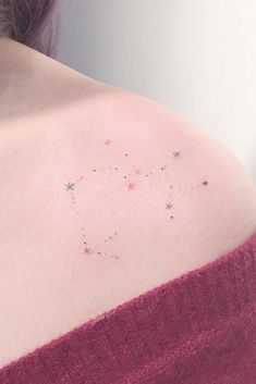 the back of a woman's shoulder with small stars on her left arm and chest