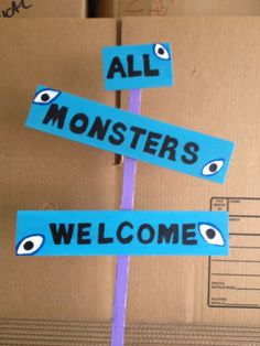 a cardboard sign that says all monsters welcome with eyes on it and an eyeball in the middle