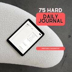 a phone sitting on top of a white pillow with the text 75 hard daily journal