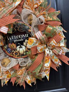 a welcome wreath is hanging on the front door for someone's fall decorating