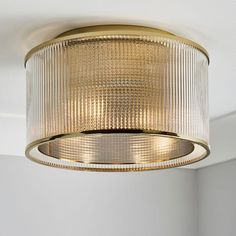 a light fixture hanging from the ceiling in a room with white walls and flooring