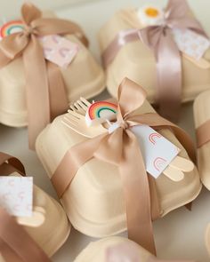 several small brown bags with ribbons around them and a rainbow brooch in the middle