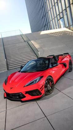 a red sports car parked in front of some stairs